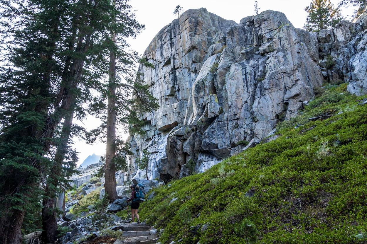 Sam hiking beneath a large granite rock in the Sierras