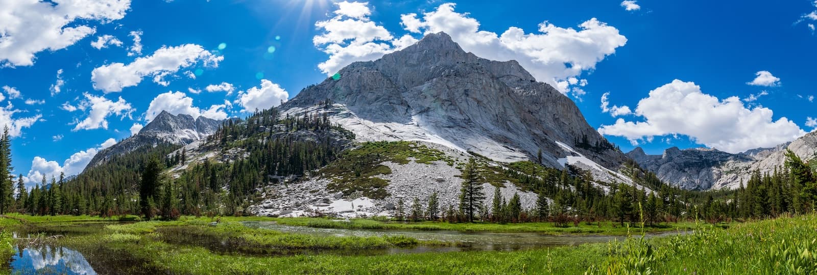 Massive canyon walls rise above an alpine meadow along the banks of the Middle Fork Kings River in Kings Canyon National Park.