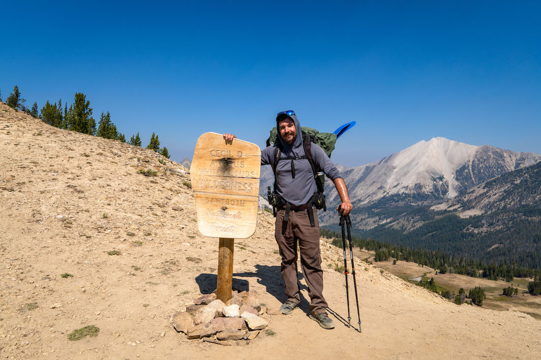 Brock Dallman standing near the White Clouds Wilderness sign
